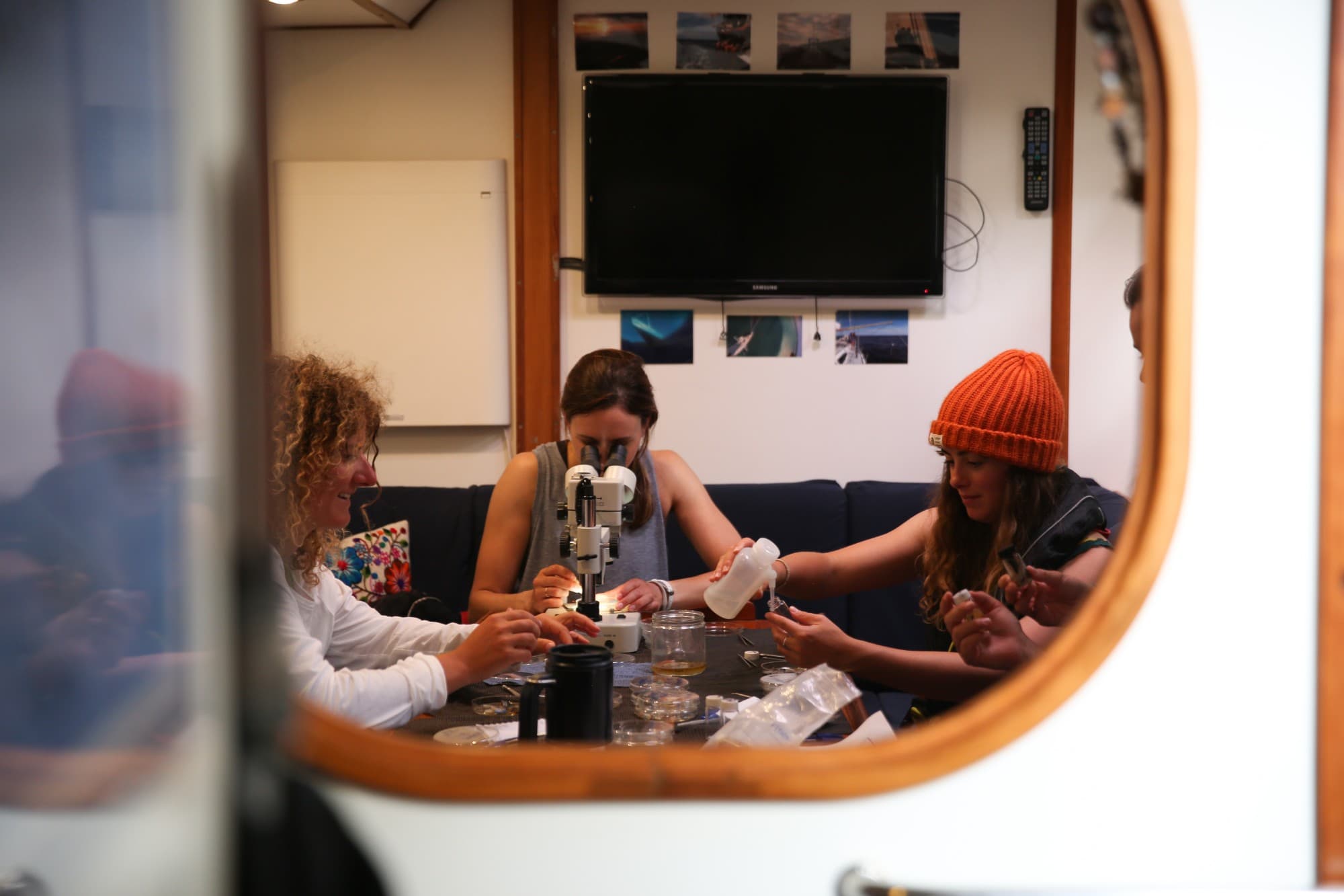 Crew analysing samples under a microscope on board